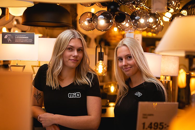 Två elever från försäljnings- och serviceprogrammet står i lampavdelningen på MIO möbler i Ludvika där de gör sin APL (arbetsförlagd lärande).